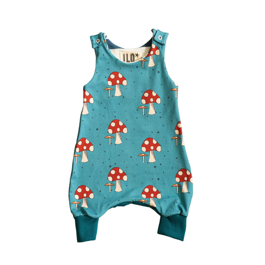 All in one romper suit with fabric with toadstools on a blue background.