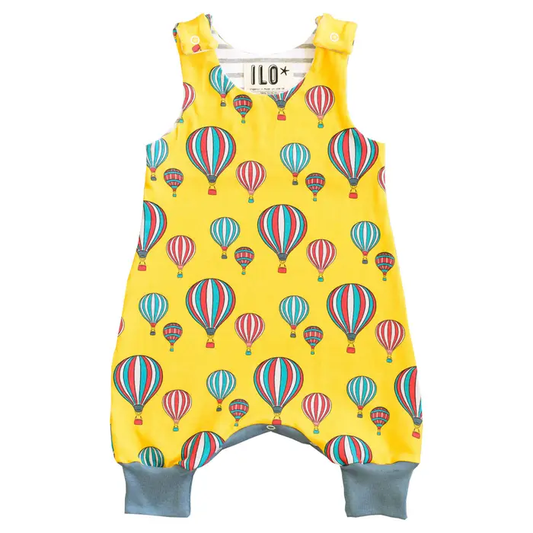 Balloons on yellow print romper, with foldable ankle cuffs and two popper settings to allow for baby growing.  made by ILO of Bristol.