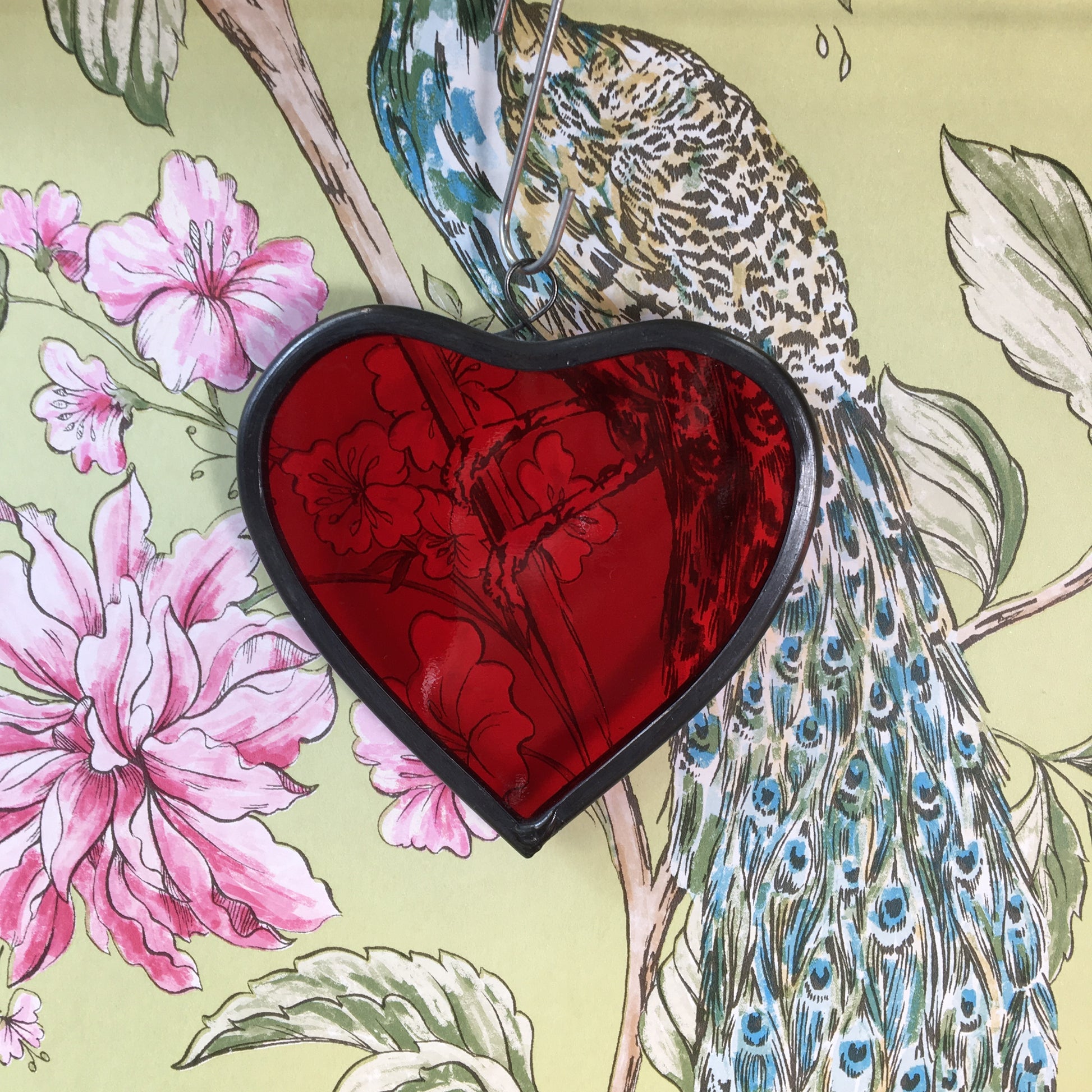 A medium sized Glass heart with a lead edging and a copper wire hook to hang in a window or outside in a tree
