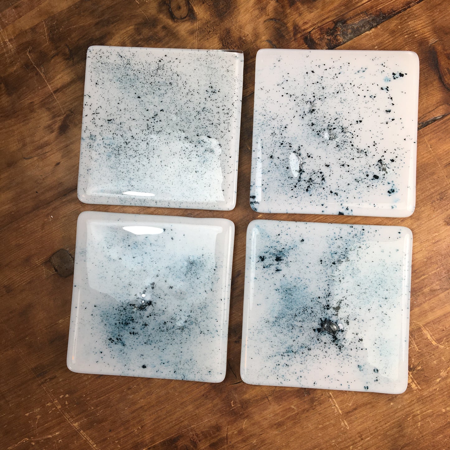 Dadswell Glass, Handmade fused glass coasters, copper oxide powder between glass creating an aqua spray of colour. Beautiful coasters to adorn your home. Made at Glass Designs a Bristol Gift shop.
