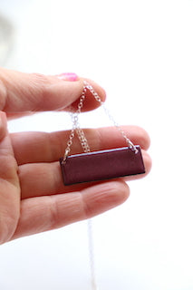 A deep purple bar necklace with a silver chain