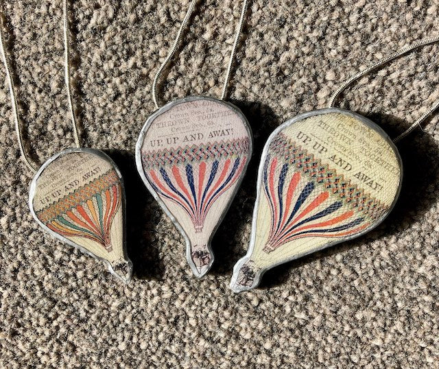 Cardiff based artist Ellymentals whimsical layered paper, metal and resin hot air balloon pendants. Small medium or large available.
