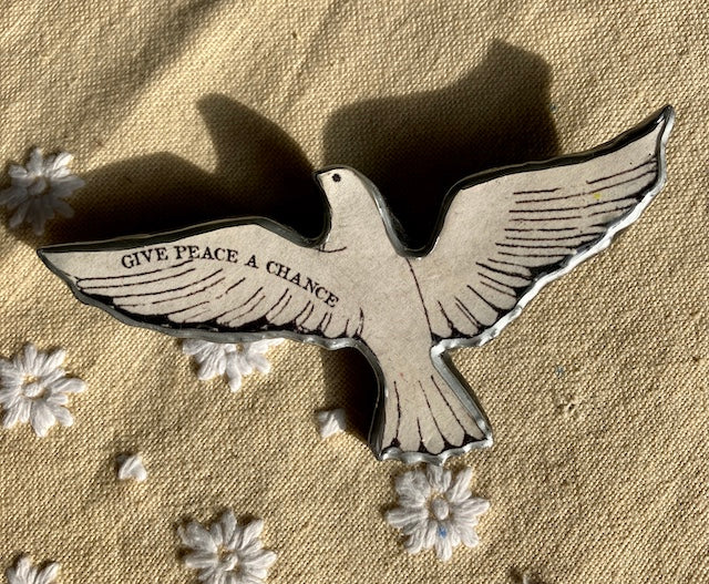 Give Peace a Chance dove brooch. Made from layered paper and metal with resin to seal.