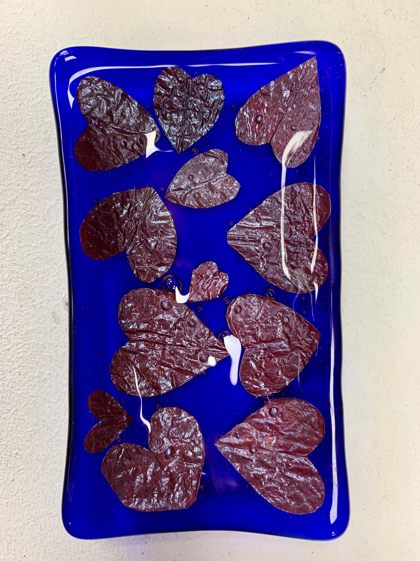 Bristol Blue Glass fused trinket dish or soap dish with Rusty red hearts fused between the glass. Handmade in Bristol.