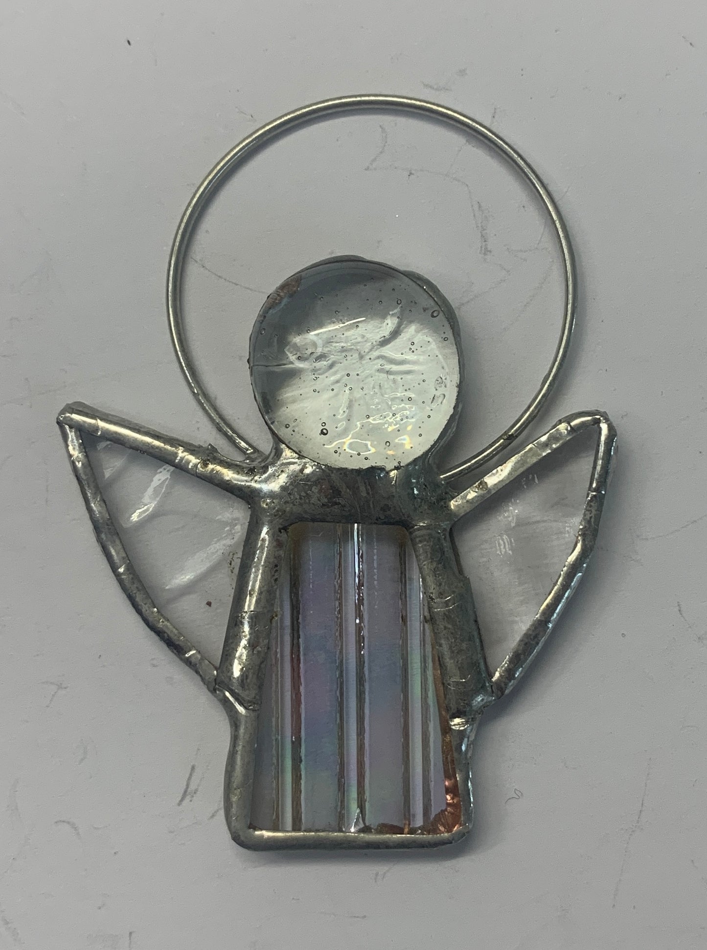 Stained Glass Angels. Individually made by hand. Many colour choices and variations. A choice of a clear or amber nugget head. The glass texture may vary slightly from the photographs. The clear glass wings will vary in texture too. Size 5cm x 7cm including halo. Glass is cut to shape and copperfoiled, followed by soldering all the pieces together. Handmade by Dadswell Glass at Glass Designs in Bristol.