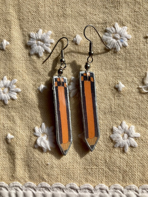 Black and orange striped quirky pencils made from layered paper, metal and resin. Surgical steel earring hooks.