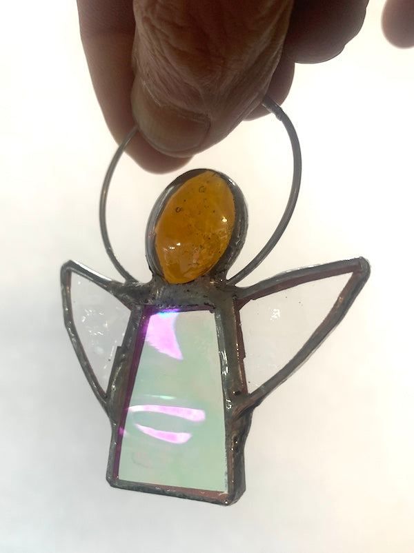 Stained Glass Angels. Individually made by hand. Many colour choices and variations. A choice of a clear or amber nugget head. The glass texture may vary slightly from the photographs. The clear glass wings will vary in texture too. Size 5cm x 7cm including halo. Glass is cut to shape and copperfoiled, followed by soldering all the pieces together. Handmade by Dadswell Glass at Glass Designs in Bristol.