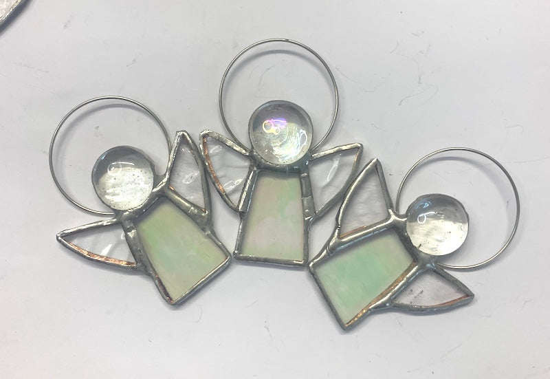 Stained Glass Angels. Individually made by hand. Many colour choices and variations. A choice of a clear or amber nugget head. The glass texture may vary slightly from the photographs. The clear glass wings will vary in texture too. Size 5cm x 7cm including halo. Glass is cut to shape and copperfoiled, followed by soldering all the pieces together. Handmade by Dadswell Glass at Glass Designs in Bristol.