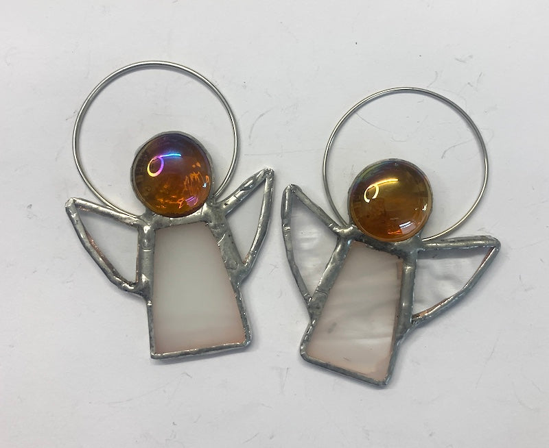 Stained Glass Angels. Individually made by hand. Many colour choices and variations. A choice of a clear or amber nugget head. The glass texture may vary slightly from the photographs. The clear glass wings will vary in texture too. Size 5cm x 7cm including halo. Glass is cut to shape and copperfoiled, followed by soldering all the pieces together. Handmade by Dadswell Glass at Glass Designs in Bristol.