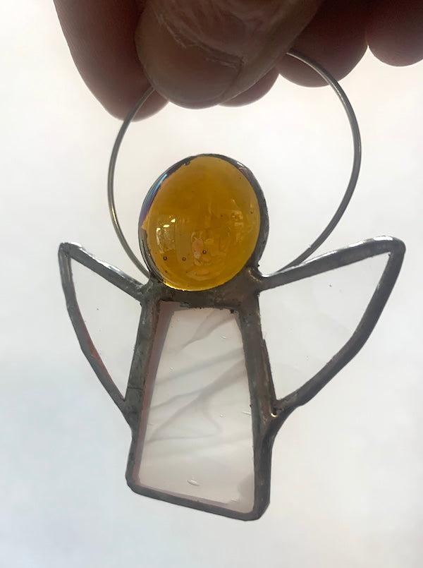 Stained Glass Angels. Individually made by hand. Many colour choices and variations. A choice of a clear or amber nugget head. The glass texture may vary slightly from the photographs. The clear glass wings will vary in texture too. Size 5cm x 7cm including halo. Glass is cut to shape and copperfoiled, followed by soldering all the pieces together. Handmade by Dadswell Glass at Glass Designs in Bristol.