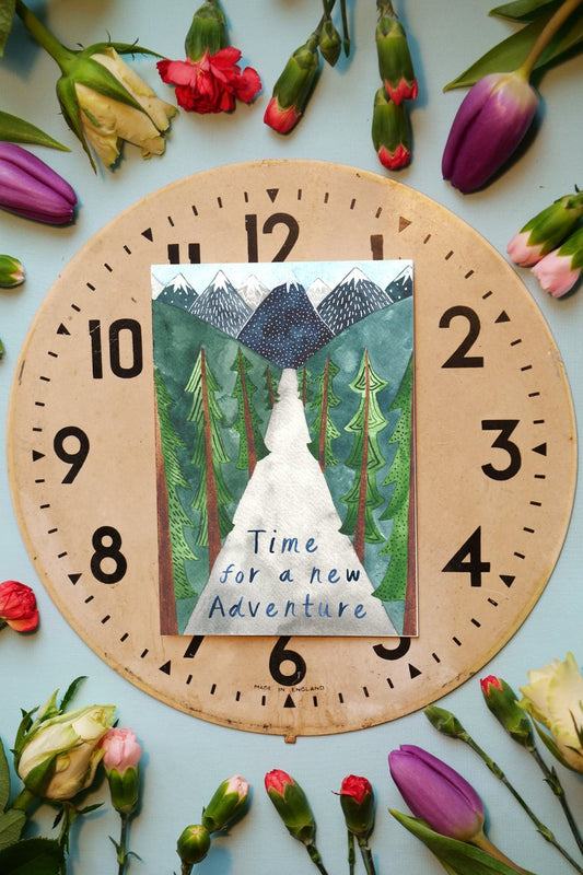 Watercolour greetings card with mountains trees and a road with the words 'Time for an adventure'