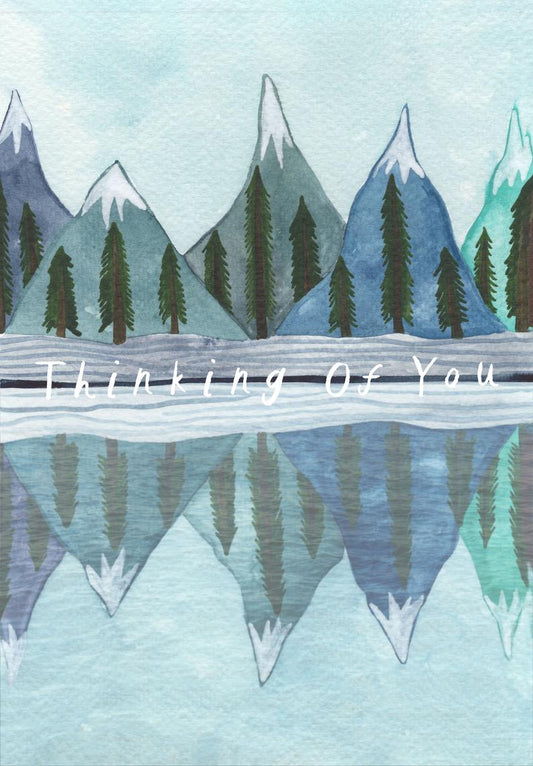 watercolour greetings card with mountains and trees reflected in a lake and the words ''thinking of you''