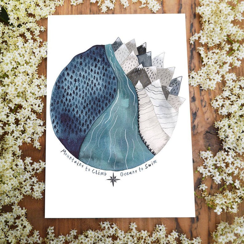 card with round blue watercolour of mountains dark sky and forest with the words ''mountains to climb oceans to swim''