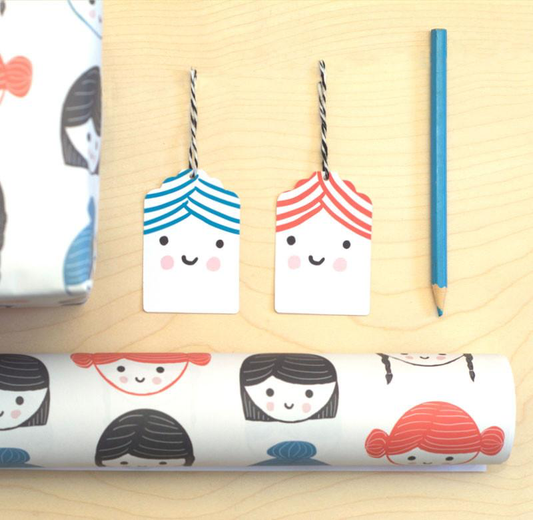 Sarah Ray Gift Wrap, Drawn faces with different hair styles. Bobs, plaits or buns. Edit alt text