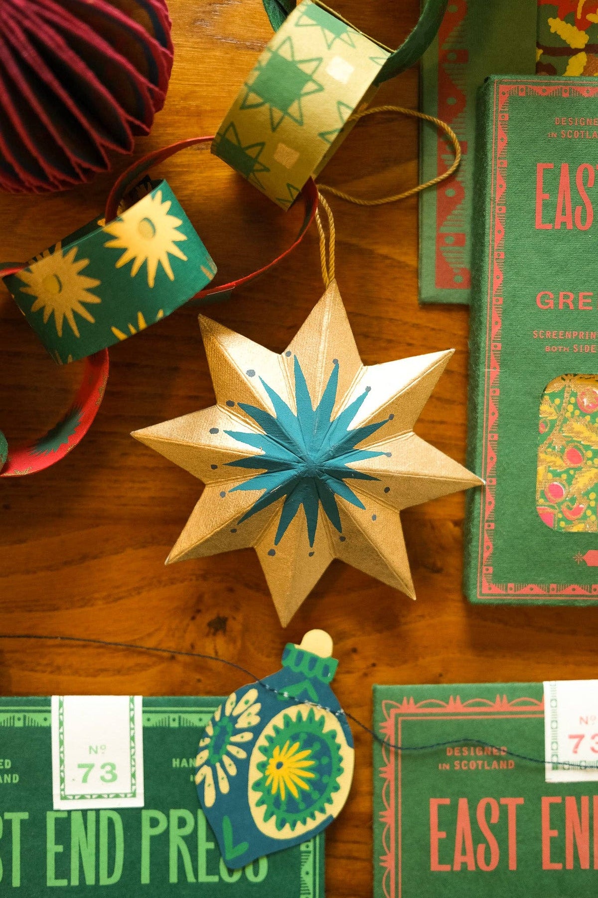 Decorative star ornament with green accents on a wooden surface with vintage books.