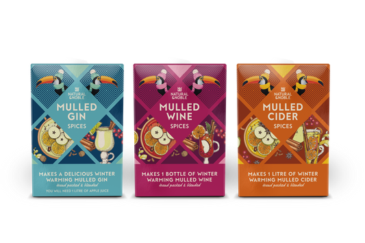 Three boxes of mulled wine spices with colorful designs on a white background