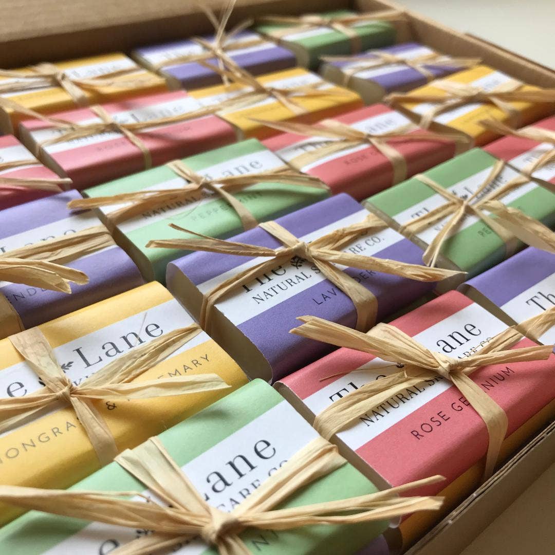 Assorted colorful soap bars in a box with visible branding.