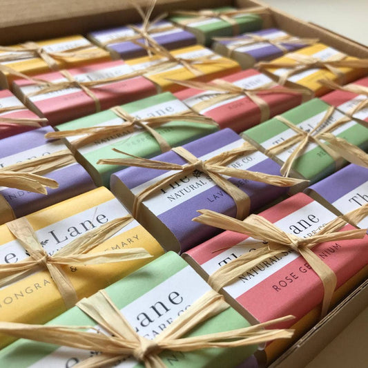 Assorted colorful soap bars in a box with visible branding.