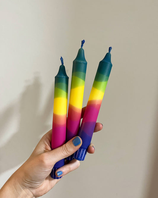 Rainbow coloured table candles.