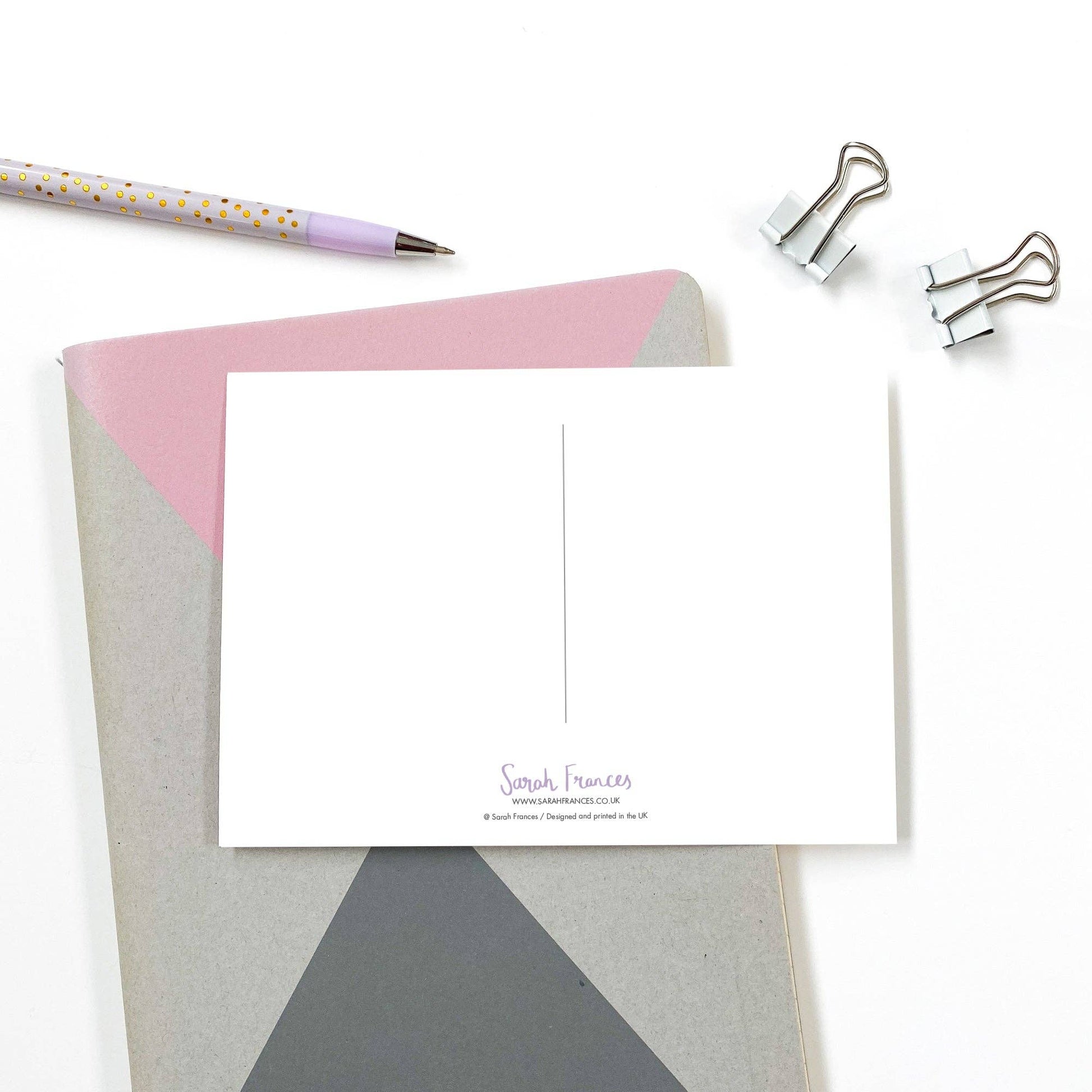 Note card with envelope and stationery items on a white background