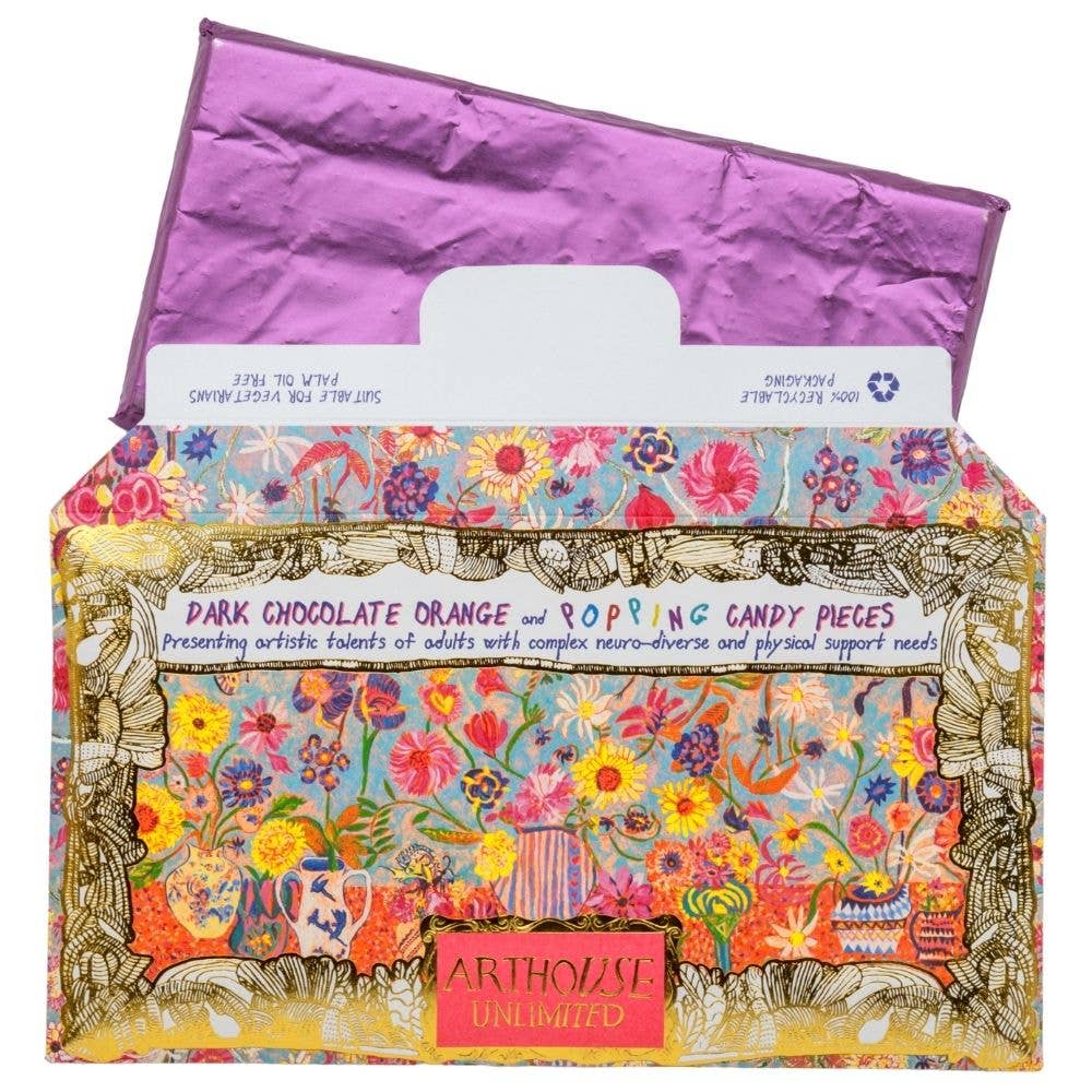 Colorful box of dark chocolate orange and popping candy pieces with a floral design and 'Arthouse Unlimited' branding.