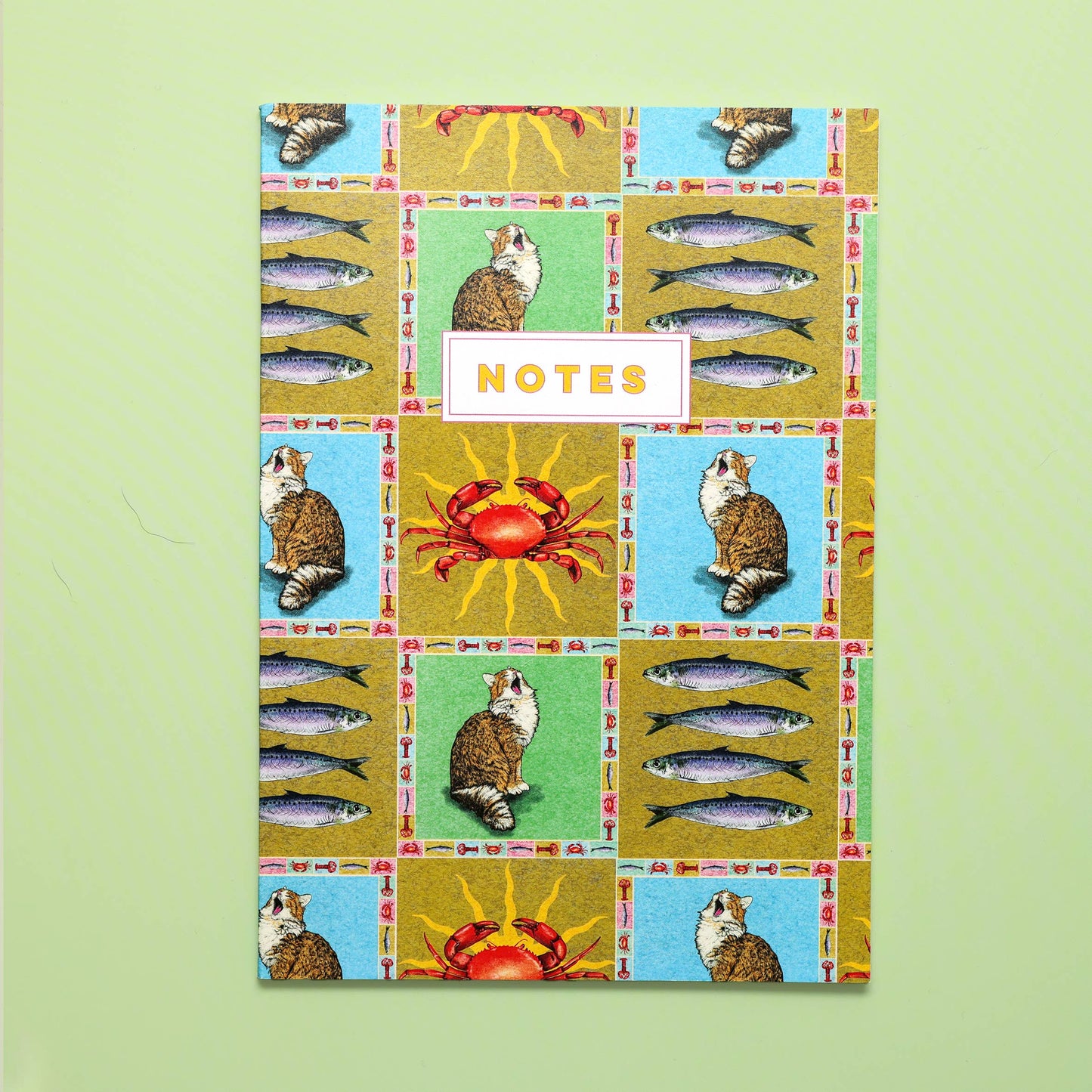 Notebook cover with a patchwork design featuring animals and fish on a green background