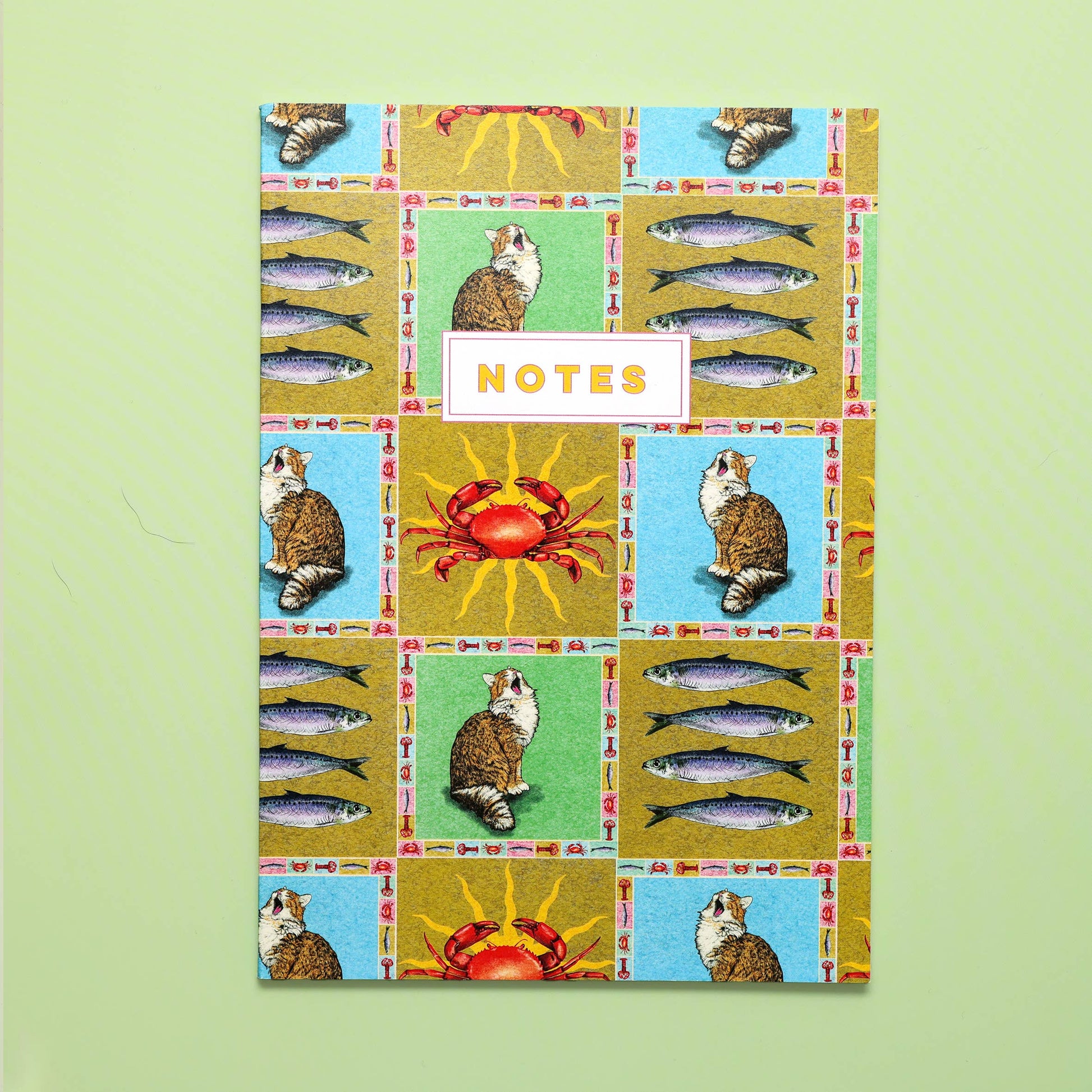 Notebook cover with a patchwork design featuring animals and fish on a green background