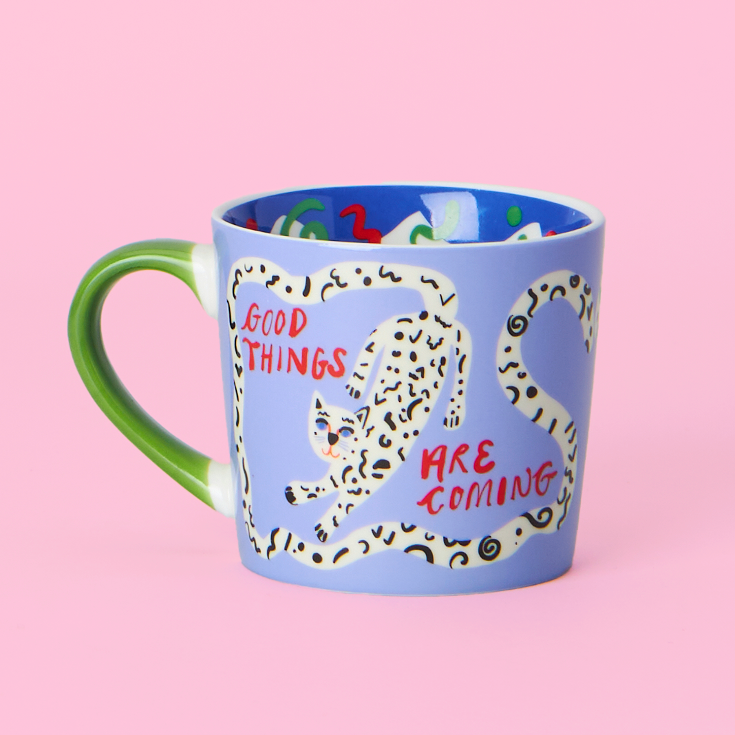 Blue mug with a cheetah design and text on a pink background