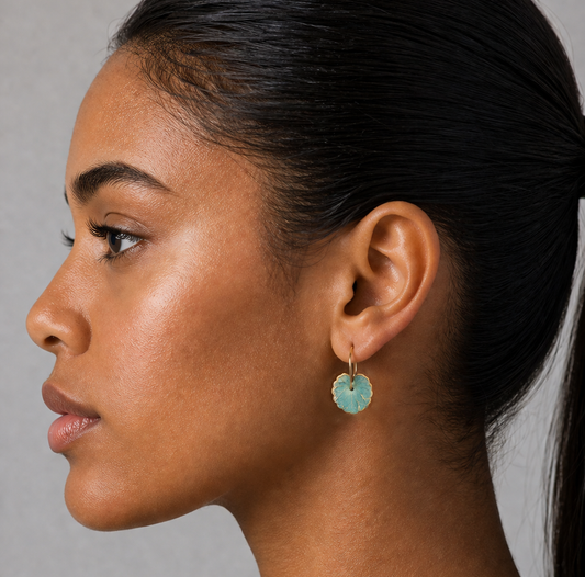 Close-up of a woman wearing a turquoise earring against a neutral background