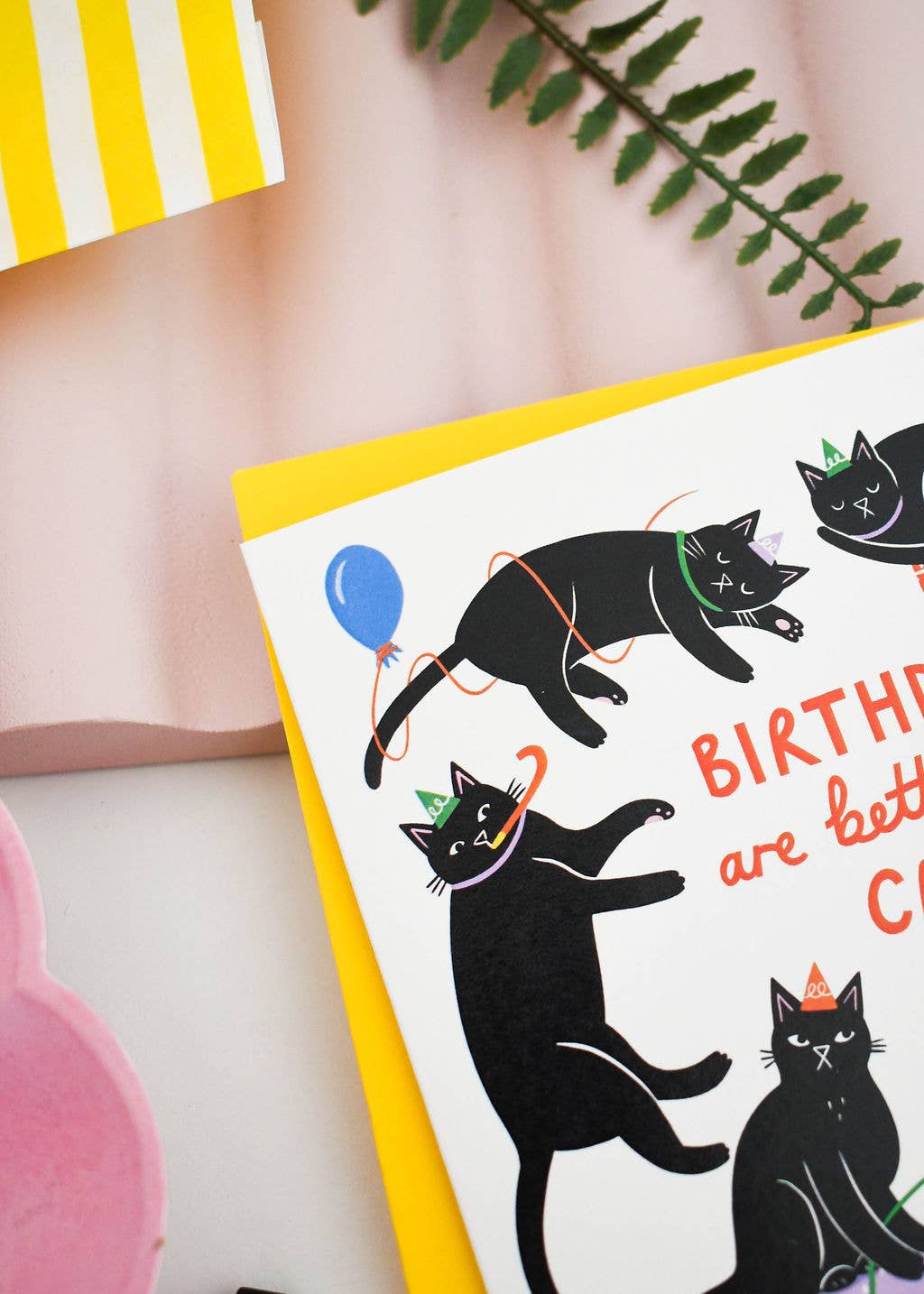 Greeting card with black cats and colorful text on a pink background