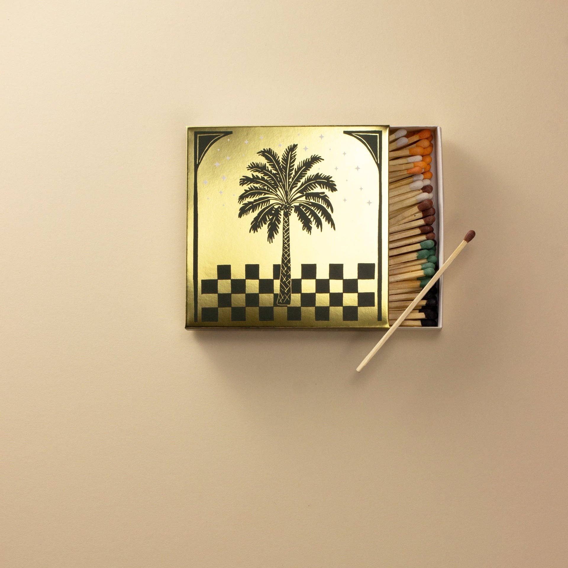Matchbox with palm tree design on a beige background