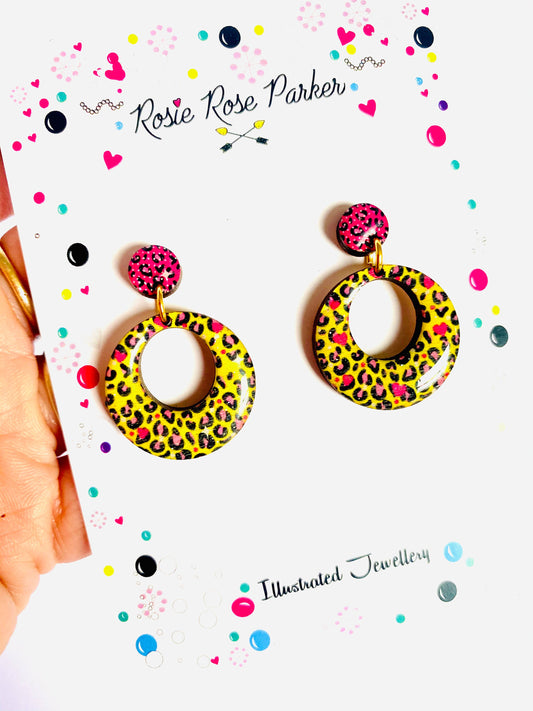 Pink and yellow leopard print earrings made from resin and wood.