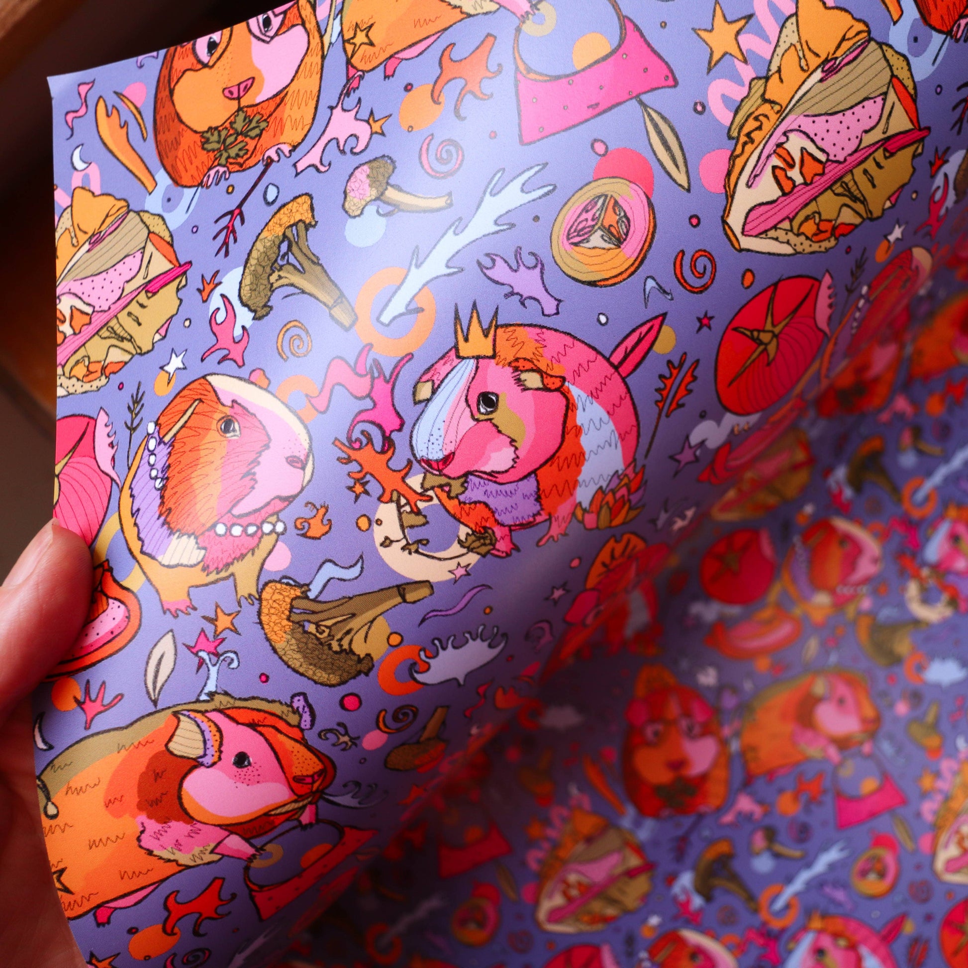 Colourful wrapping paper with guinea pigs wearing crowns.