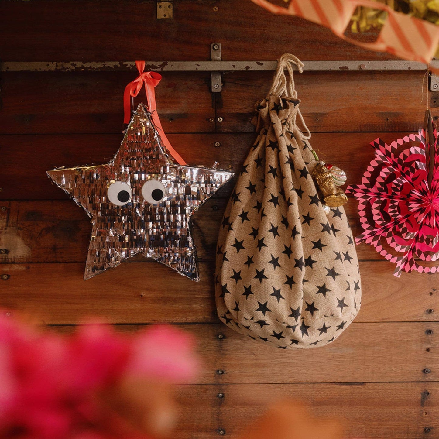 Decorative star-shaped bag with googly eyes and a drawstring bag with star pattern on a wooden surface.
