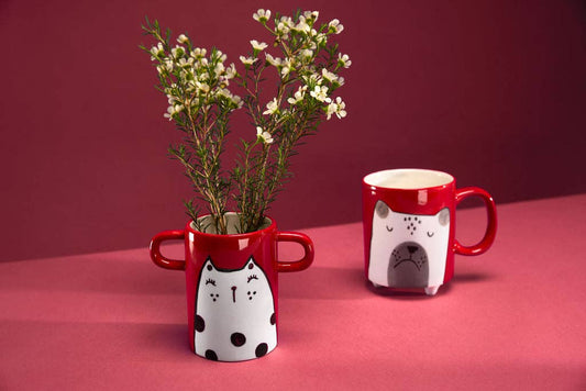 Yellow vase with handles and black cat illustration.