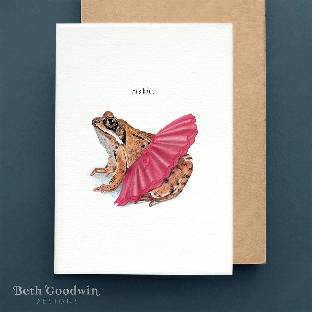 Greeting card with a frog wearing a pink tutu and 'ribbit' text, on a white background with a brown envelope.