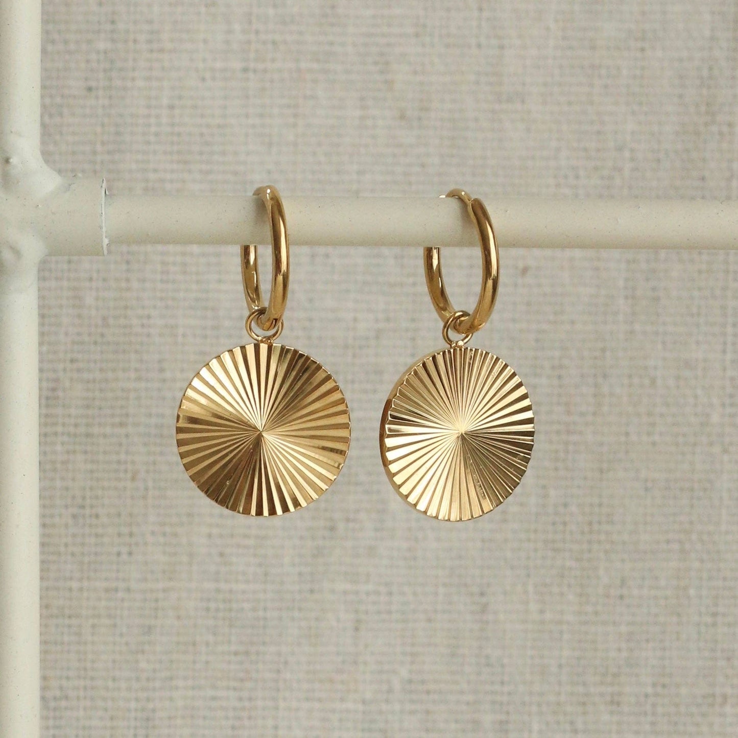 Round facetted gold plated earrings on hoops.