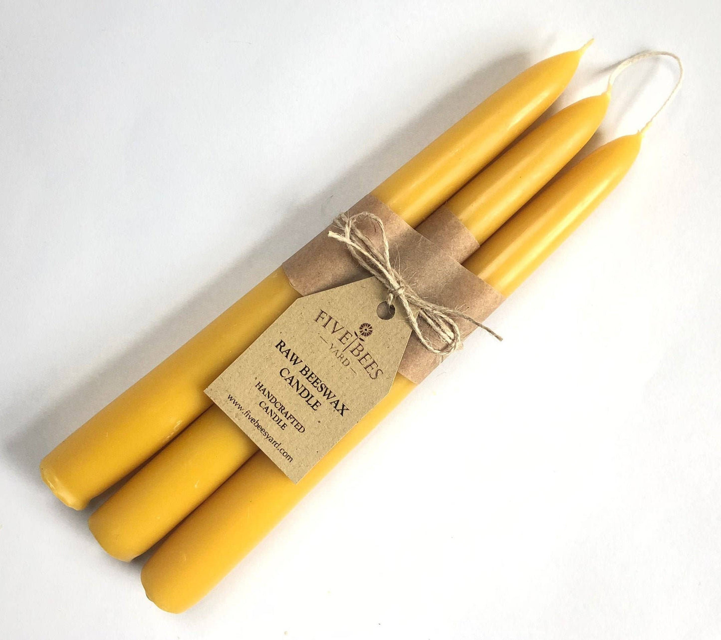 Set of yellow candles with a Five Bees label on a white background