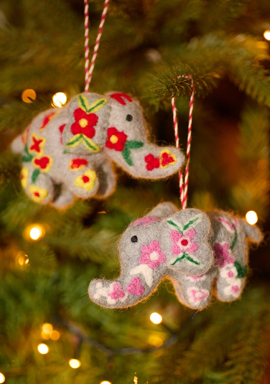 Two embroidered felt elephant decorations with red and white hanging cords, featuring colorful floral patterns.