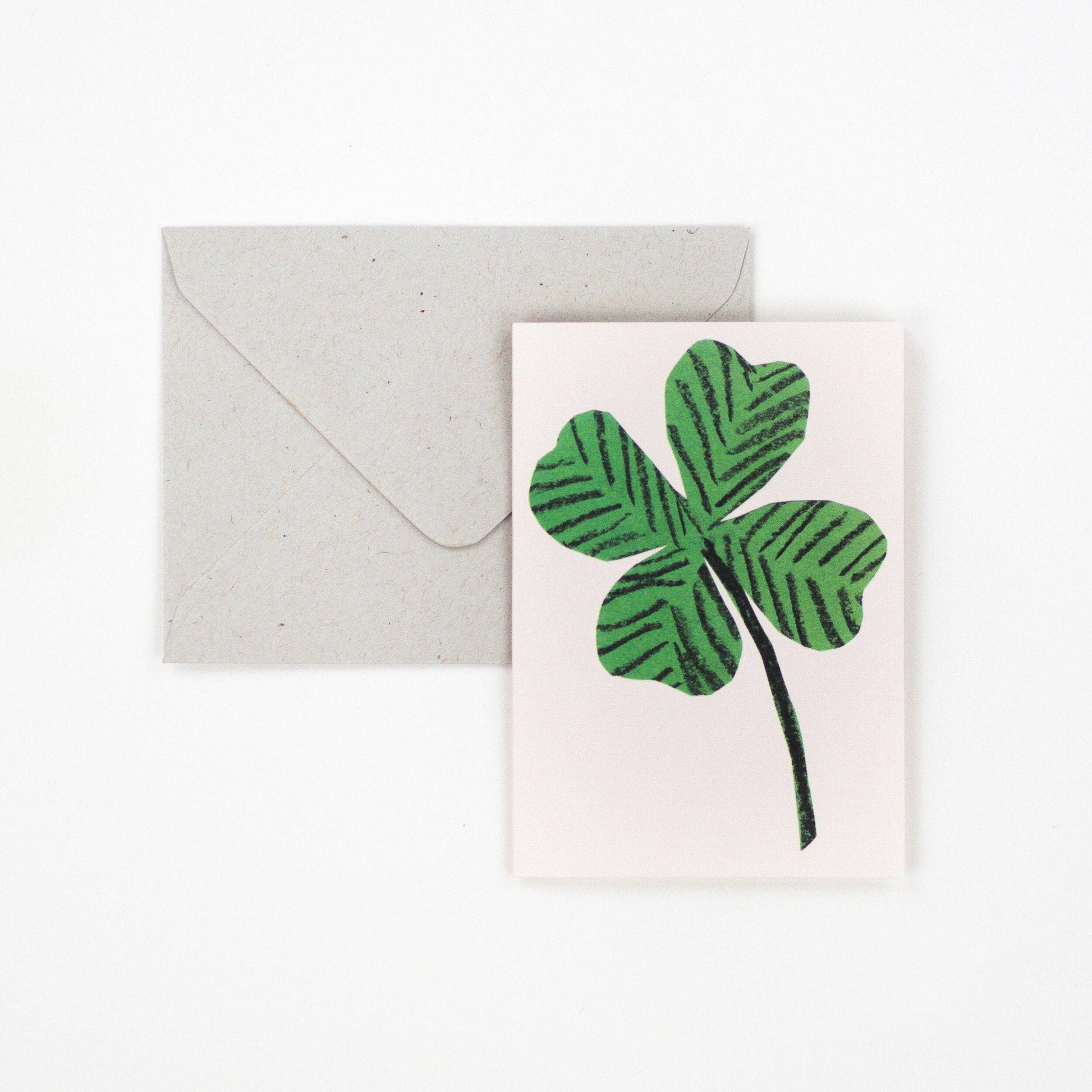 Small greetings card with a 4 leaf clover on a white background.