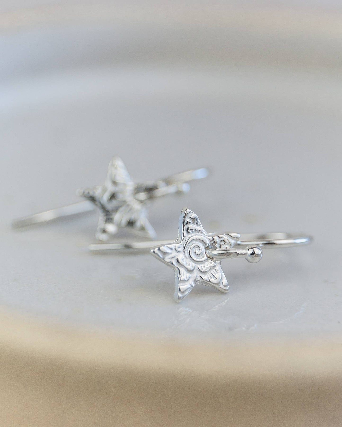 Silver star-shaped rings on a light background