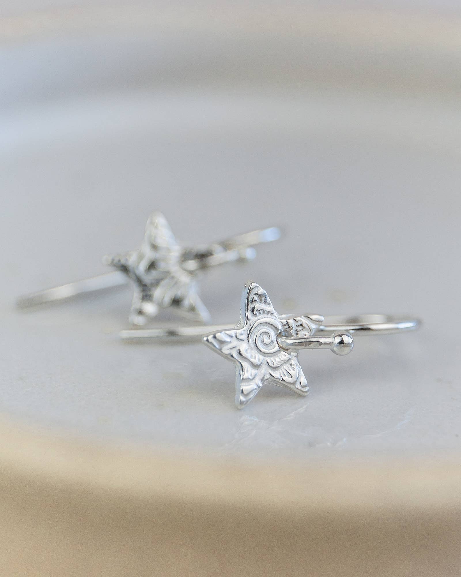 Silver star-shaped rings on a light background