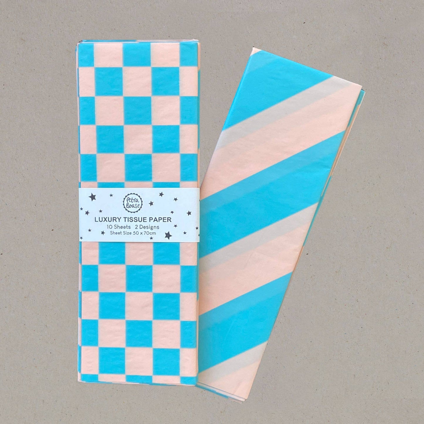 Packaged luxury tissue paper with checkered and striped designs on a gray background