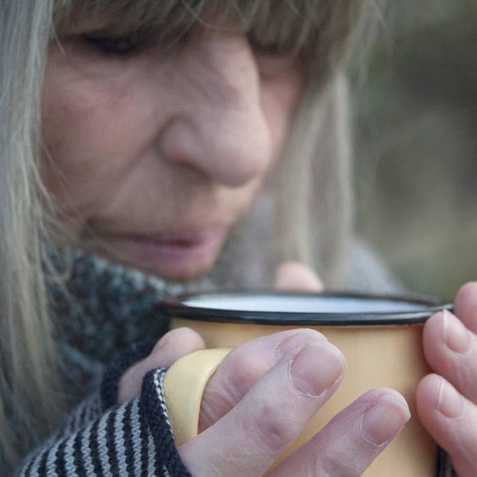 Person holding a yellow mug with a blurred background