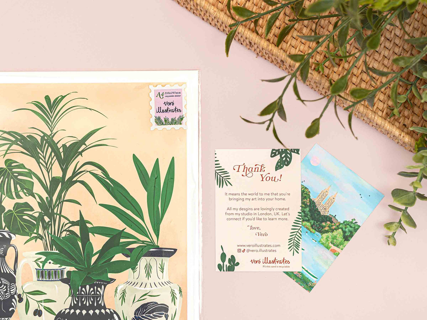 Greeting card with plant-themed design on a pink surface with green leaves.