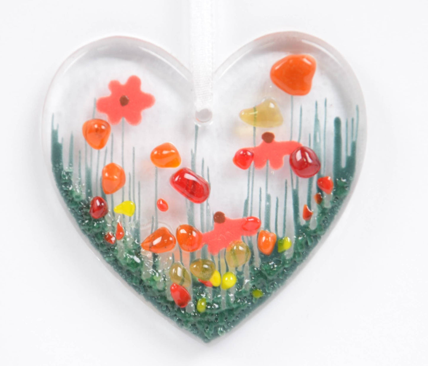 Heart-shaped glass ornament with colorful flowers on a white background