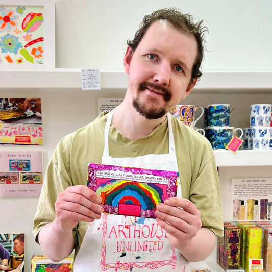 Man holding a colorful card with a rainbow design in a store setting