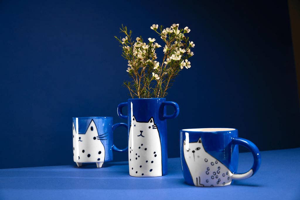 Blue vase with handles and white cat illustration.