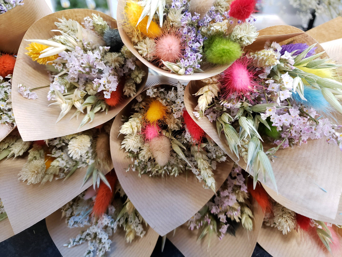 Bouquets of flowers in wooden containers with colorful accents.