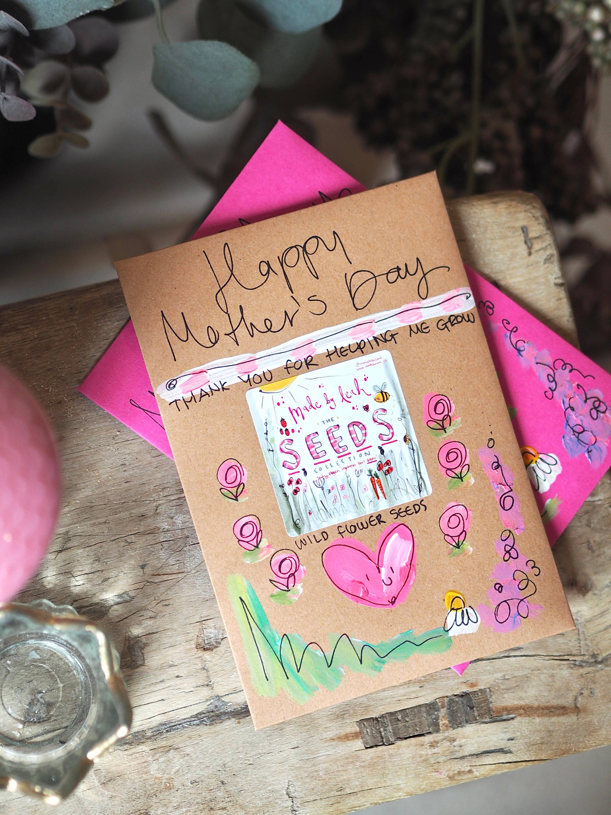 Handmade Mother's Day card with decorative elements on a wooden surface.